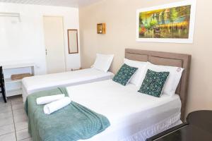 two beds in a small room with a table at Pousada Villa Goyá in São José da Coroa Grande