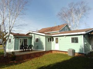 a green and white house with a deck at Cozy Quincy by The Jordan Company in Bruce Mines