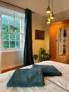a bedroom with a bed with a large window at Room 1, Wedale House in Stow
