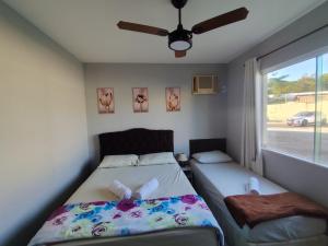 ein Schlafzimmer mit zwei Betten und einem Fenster in der Unterkunft Apartamento Térreo 2 Quartos Com Clube Privativo - Condomínio Marina Clube in Cabo Frio + 26 Fotos