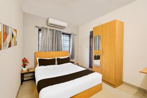 una camera da letto con un letto grande in una stanza di Super Townhouse Nanganallur Near Chennai Airport a Chennai