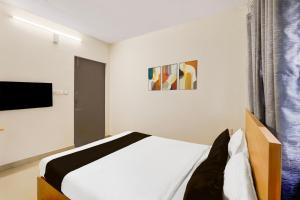 una camera da letto con un letto e una tv di Super Townhouse Nanganallur Near Chennai Airport a Chennai