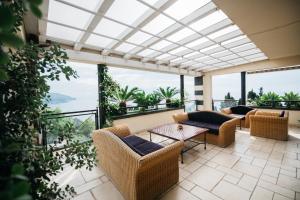 a balcony with chairs and tables and a view of the ocean at Taormina Helas Apartment by Taormina Holidays in Taormina