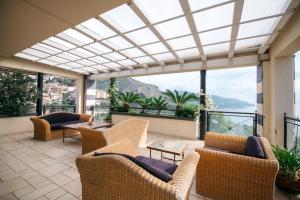 a living room with chairs and tables and a large window at Taormina Helas Apartment by Taormina Holidays in Taormina