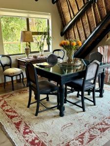 Un comedor con una mesa y sillas negras. en Shire Lodge, en Ciudad del Cabo