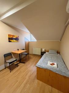 a bedroom with a bed and a desk and a table at Rooms with private Bathroom & Free Parking ''Sobe Zoka,, in Subotica