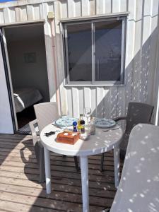 a white table on a deck with a meal on it at Cabañas ecológicas Tongoy in Tongoy