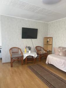 a room with two chairs and a table and a tv at YNA - Self Check-In Stay in Ocna-Mureşului