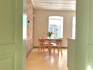 d'une salle à manger avec une table, des chaises et un mur en briques. dans l'établissement Lake stay in Viljandi with Parking, à Viljandi