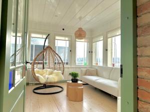 un salon avec un canapé blanc et une balançoire dans l'établissement Lake stay in Viljandi with Parking, à Viljandi