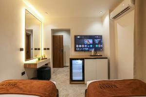 a hotel room with two beds and a flat screen tv at Royal Regency Eg Hotel in Cairo