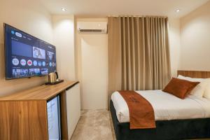 a hotel room with a bed and a flat screen tv at Royal Regency Eg Hotel in Cairo