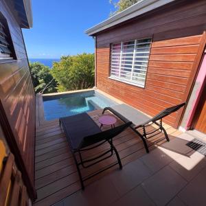 a patio with a table and chairs next to a swimming pool at Domaine Racines e Zel - Gîte PomKajou in Vieux-Fort