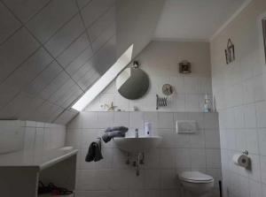 a white bathroom with a sink and a toilet at Appartement In Nindorf Mit Garten in Nindorf +12 photos