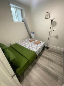 a bedroom with a green bed and a window at Exclusive Queen St Downtown Full House-PRIVATE PATIO in Toronto