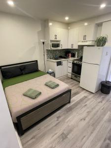 a bedroom with a bed and a kitchen with white cabinets at Exclusive Queen St Downtown Full House-PRIVATE PATIO in Toronto +3 photos