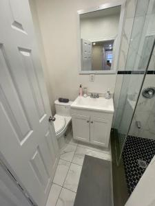 a bathroom with a sink and a toilet and a mirror at Exclusive Queen St Downtown Full House-PRIVATE PATIO in Toronto