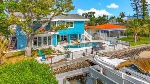 una casa blu con piscina e barca di Luxury Maderia Beach waterfront home with pool-spa a St Pete Beach