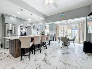 una cucina con bar, sedie e tavolo di Luxury Maderia Beach waterfront home with pool-spa a St Pete Beach