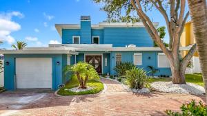 una casa blu con palme di fronte di Luxury Maderia Beach waterfront home with pool-spa a St Pete Beach