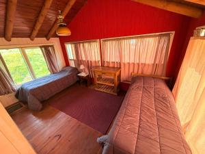 a bedroom with two beds and a table in a room at Tres Coronas in San Martín de los Andes