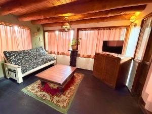 a living room with a couch and a flat screen tv at Tres Coronas in San Martín de los Andes
