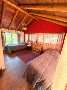 a bedroom with two beds and a wooden ceiling at Tres Coronas in San Martín de los Andes