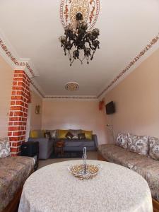 a living room with a table and a chandelier at Groupe appart-La casa de Wael in Ifrane