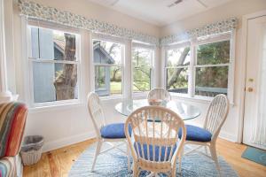 a dining room with a table and chairs and windows at Paws4ever II in Edisto Island