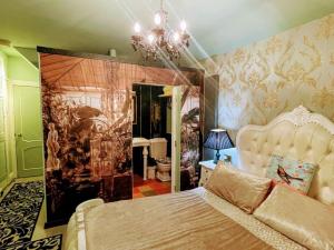 a bedroom with a bed and a chandelier at Spend a night in Paris whilst visiting Swansea in Swansea