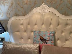 a white headboard of a couch with a bird pillow at Spend a night in Paris whilst visiting Swansea in Swansea