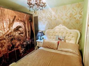 a bedroom with a large bed and a chandelier at Spend a night in Paris whilst visiting Swansea in Swansea