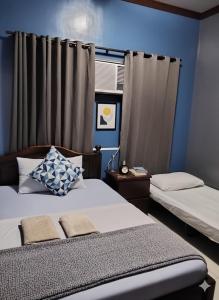 une chambre avec deux lits et un mur bleu dans l'établissement Mactan District Budgetel - Lapu Lapu Cebu, à Mactan 21 autres photos