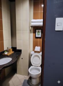 une salle de bains avec toilettes et lavabo dans l'établissement Mactan District Budgetel - Lapu Lapu Cebu, à Mactan