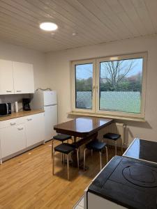 a kitchen with a table and chairs in a room at Zimmer 1 in Bullendorf