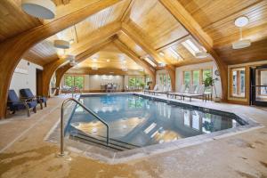 une piscine intérieure dans une maison avec un plafond en bois dans l'établissement Cozy 2BR Highridge Condo Unit I3 in Killington, VT with hot tub and scenic woods view., à Killington Village