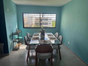 a dining room with a table with chairs and a window at Arboleda in San Pedro de Macorís