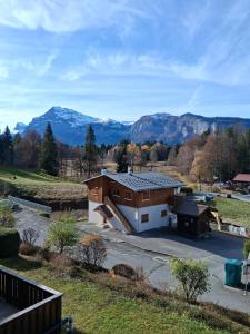 Studio SnowCarroz with a view for 4 people في Arâches-la-Frasse: مبنى كبير مع الجبال في الخلفية