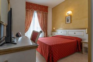 a hotel room with a red bed and a television at Hotel King in Rimini