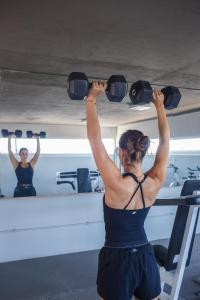 a woman is lifting weights in a gym at The Point Casa Edificio Boutique in San Miguel de Tucumán