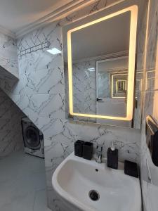 a bathroom with a white sink and a mirror at El jebha in El Jebha