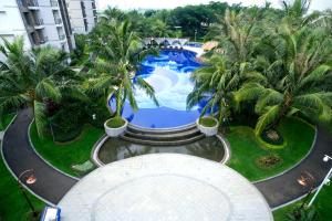 an overhead view of a swimming pool with palm trees at Sky House BSD D2-3A - 3 Bedroom Type in Samporo