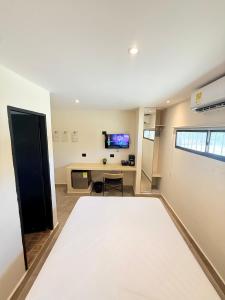 The Host at Santa Marta في سانتا مارتا: غرفة بها مكتب وتلفزيون على الحائط