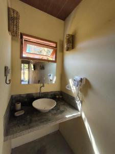 a bathroom with a sink and a mirror at Há Mar Chalés Corumbau in Prado