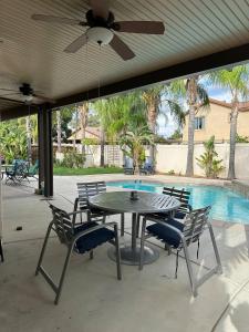 eine Terrasse mit Tisch und Stühlen und einem Pool in der Unterkunft Oasis in Southern California for 8 guests in Winchester