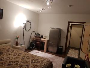 a bedroom with a bed and a refrigerator and a mirror at Graeff sweet apartment in Cologne