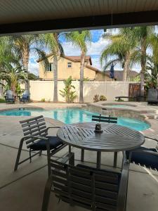 eine Terrasse mit Tisch und Stühlen neben einem Swimmingpool in der Unterkunft Oasis in Southern California for 8 guests in Winchester