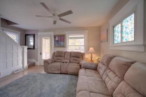 un salon avec un canapé et un ventilateur de plafond dans l'établissement Yard, Fire Pit and Trails! Pet-Friendly Akron Home, à Akron