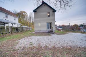 une petite maison sur une route en gravier à côté d'une maison dans l'établissement Yard, Fire Pit and Trails! Pet-Friendly Akron Home, à Akron
