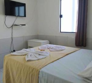 a bedroom with a bed with two towels on it at Ilheus - Pousada Sol e Mar in Ilhéus +8 photos